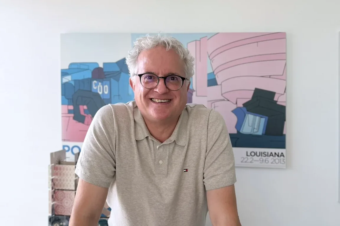 Andreas Bauer in seinem Büro vor einem Pop-Art-Plakat